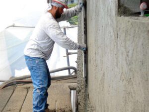 Construction worker smoothing concrete wall