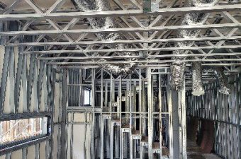 Interior of a building under construction with exposed framing and ceiling.