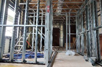 Interior of a building under construction with metal framing and exposed wiring.