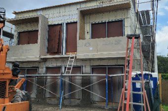 Building under construction with scaffolding and ladders.