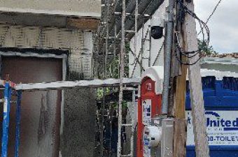 Workers on scaffolding repairing a building facade.