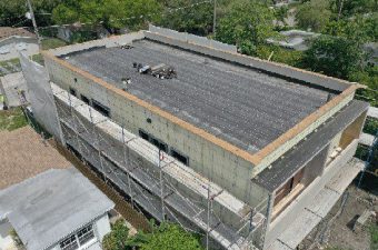 Flat roof construction on a modern building with scaffolding.
