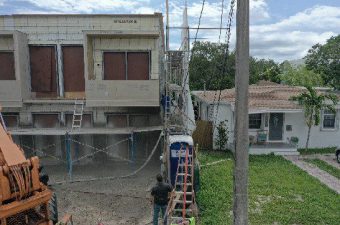 Construction workers building a two-story house with scaffolding.