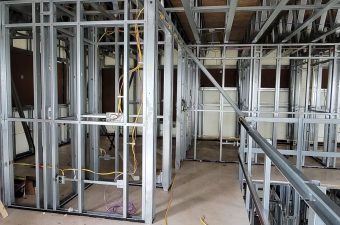 Interior construction site with metal framing and exposed ceiling.