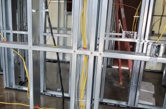Metal stud framing with electrical wiring in a building under construction.