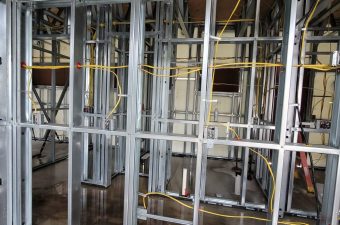 Metal framing and electrical wiring installation in a building under construction.