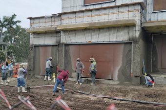 Workers preparing a construction site with rebar and concrete.