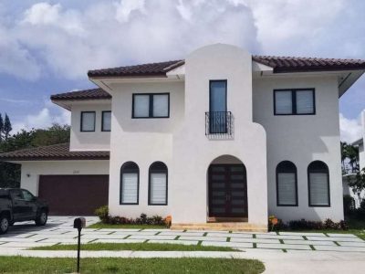 Modern two-story white house with arched windows and a tiled roof.