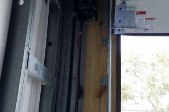 Interior view of a bus door with safety instructions and window.