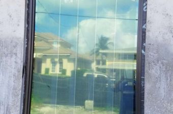 A reflective glass door with a security sticker.
