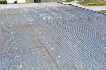 Steel reinforcement grid laid out for concrete slab foundation.