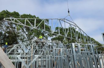 Crane lifting a large roof truss