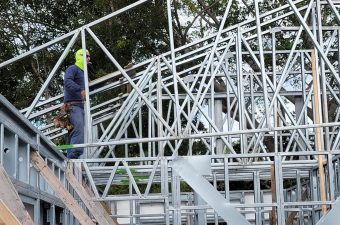 Worker assembling metal framework of a building under construction.