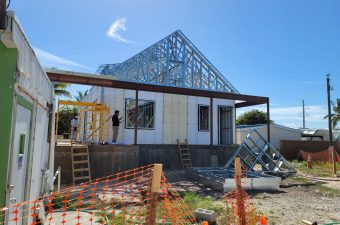 House under construction with a steel frame roof structure.