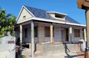 House under construction with solar panels on the roof.