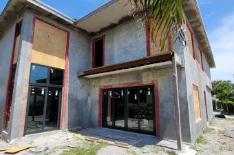 Two-story building under construction with open windows and doors.