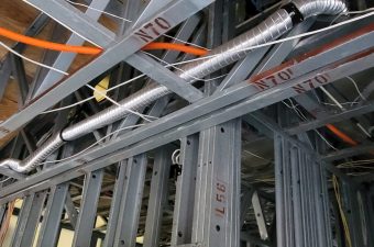Exposed HVAC ductwork and framing inside a building under construction.