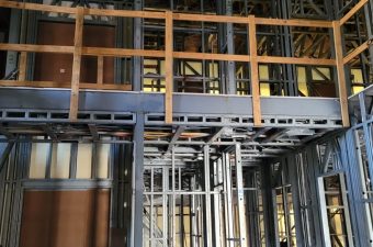 Exposed framework and piping in a building under construction.