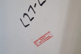 A piece of paper with handwritten numbers and a small red stamp.