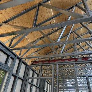 Exposed wooden ceiling with metal trusses in industrial space.