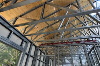 Exposed wooden ceiling with metal beams in a modern industrial interior.