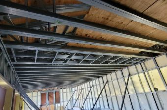 Ceiling framing and beams under construction in a building.