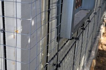 Protective netting installed around an outdoor air conditioning unit.