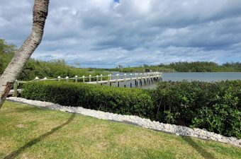Scenic view of a wooden pier extending into calm waters under a cloudy sky.