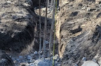A construction site trench with exposed rebar for concrete foundation.