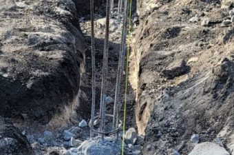 A construction site trench with exposed rebar for concrete foundation.