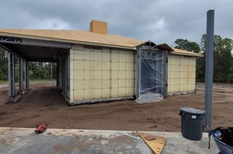 A building under construction with insulated concrete forms and a covered entrance.