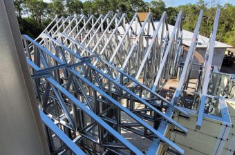 Steel truss bridge under construction over a waterway.