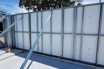 Metal wall frame with supporting braces outdoors.
