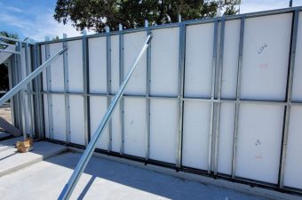 Metal wall frame with supporting braces outdoors.