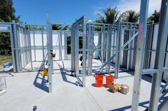 Steel frame structure being assembled on a sunny day.