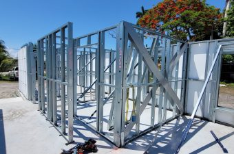 Steel frame structure under construction with tools on the ground.