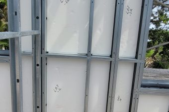 Metal framework supporting white panels with numbers marked on them.