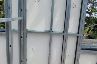 Metal framework supporting white panels with numbers marked on them.