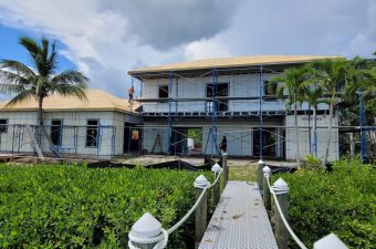 A house under construction with scaffolding and a cloudy sky.