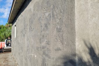 Concrete sidewalk with faint chalk drawings and shadows.