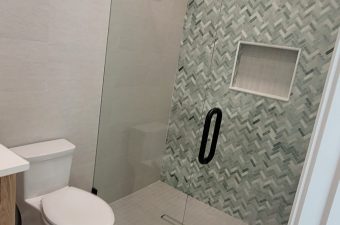 Modern bathroom with glass shower and white toilet.
