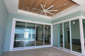 Modern room with large ceiling fan and glass sliding doors.