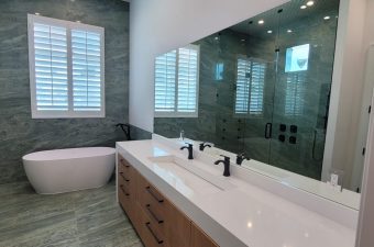 Modern bathroom with double sink and large mirror.