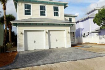 Modern two-story house with a double garage and paved driveway.