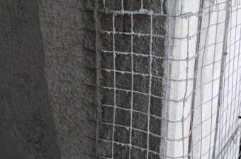 Close-up of a wire mesh corner reinforcement on a wall.