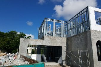 Construction site with a building framework under a blue sky.