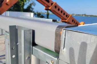 Close-up of metal beams and structural components under clear blue sky.