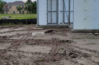 Construction site with building foundation and muddy ground.