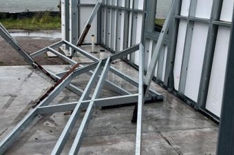 Metal framework structure under construction on a concrete floor.