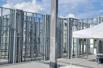 Steel framework under construction at a building site on a clear day.